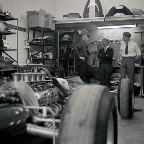 Dans le garage pendant les essais, Dan Gurney en conversation avec Colin Chapman tandis que Jimmy est au volant dans la Lotus